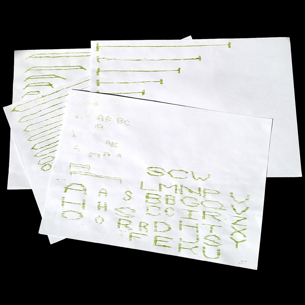 Tres fulls blancs amb esbossos de lletres en color verd.